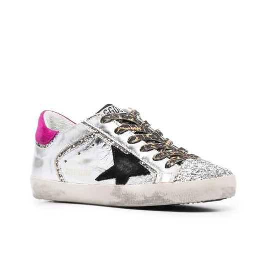 Golden Goose Superstar sneakers featuring a silver leather upper a black suede star and a magenta suede heel tab