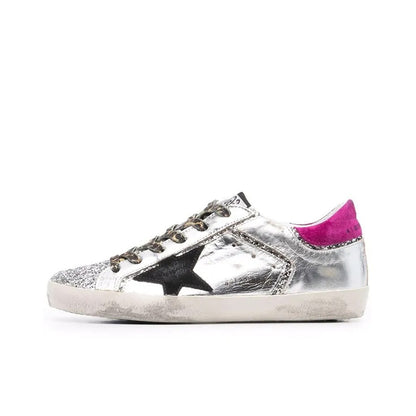 Golden Goose Superstar sneakers featuring a silver leather upper a black suede star and a magenta suede heel tab
