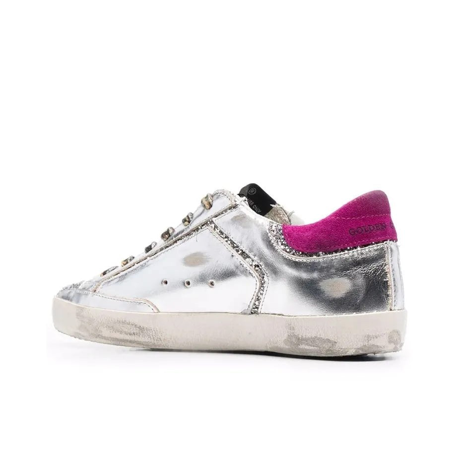 Golden Goose Superstar sneakers featuring a silver leather upper a black suede star and a magenta suede heel tab